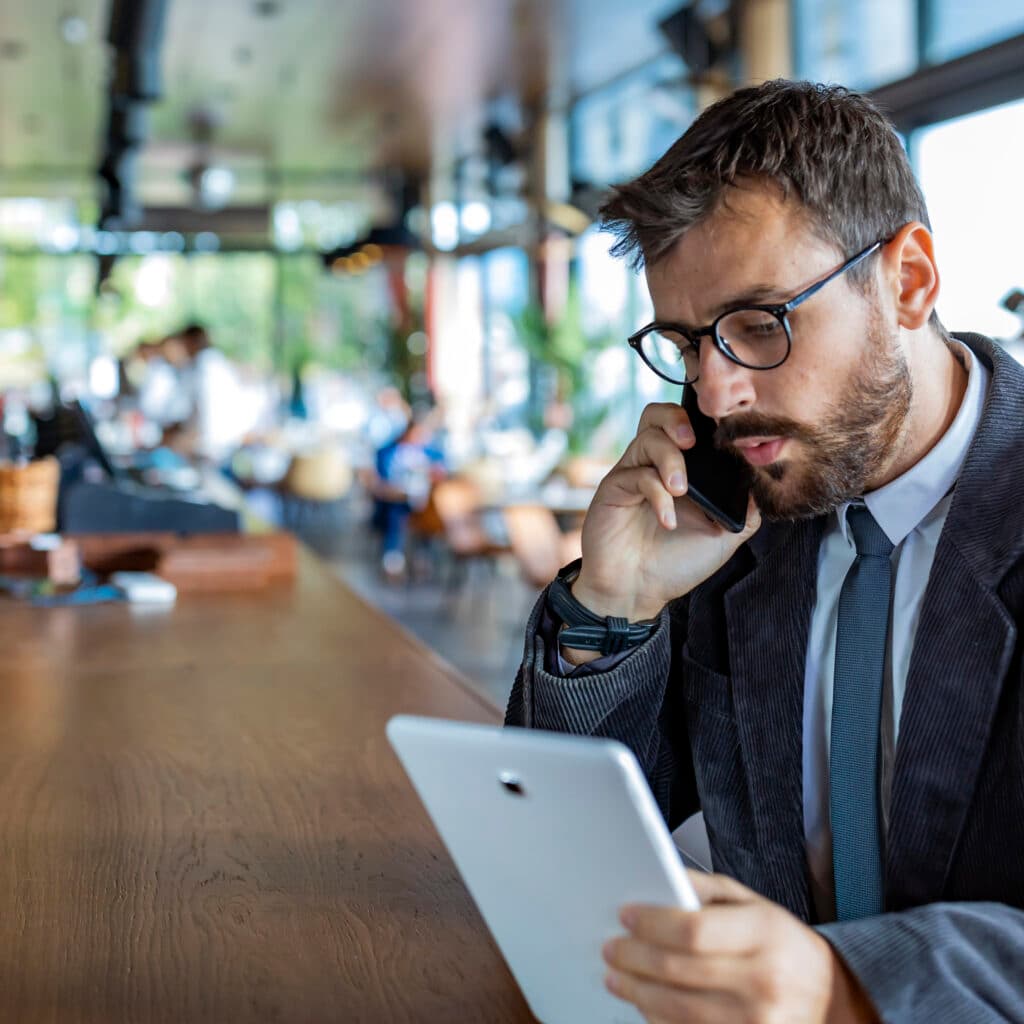 Happy and Successful Male Business Person with Beard, Dressed in Casual Suit is Communicating over a ...