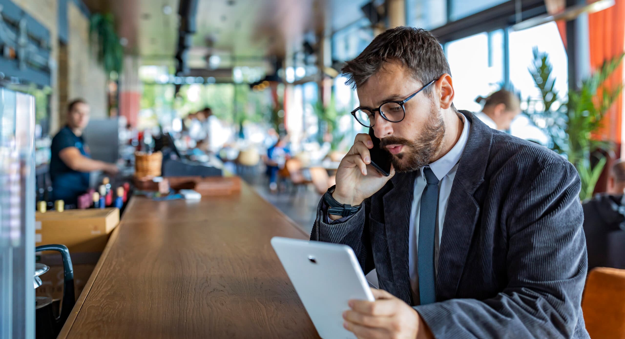 Happy and Successful Male Business Person with Beard, Dressed in Casual Suit is Communicating over a ...